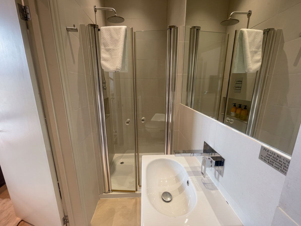 Hastings House Bedroom 2 ensuite — shower enclosure with rain head and Wild England toiletries