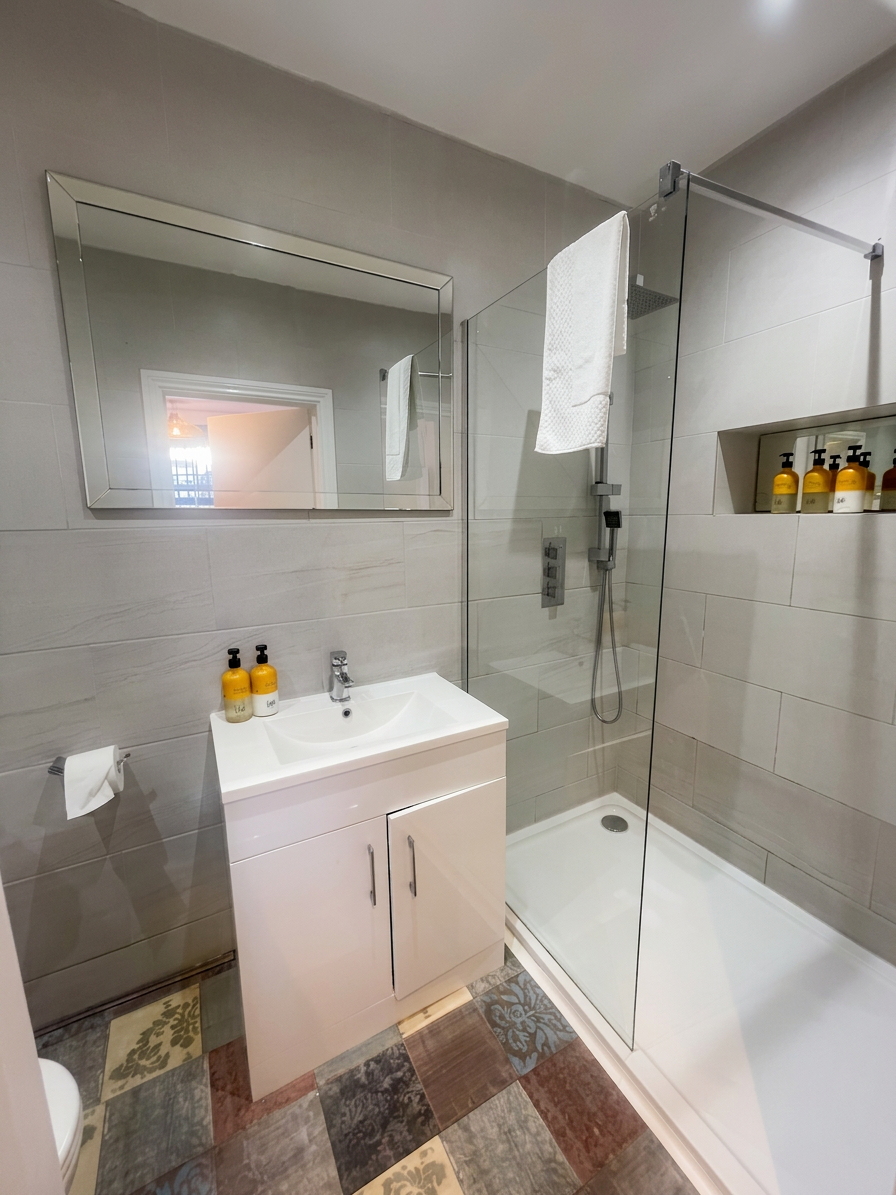 Hastings House Bedroom 8 ensuite — grey tiles, walk-in shower and wall-hung basin