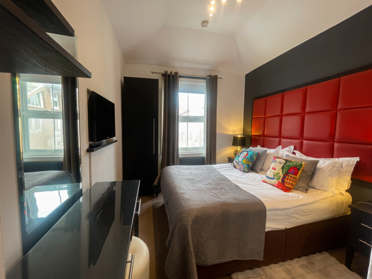 Hastings House Bedroom 1 — bold red leather headboard with Frida Kahlo cushions