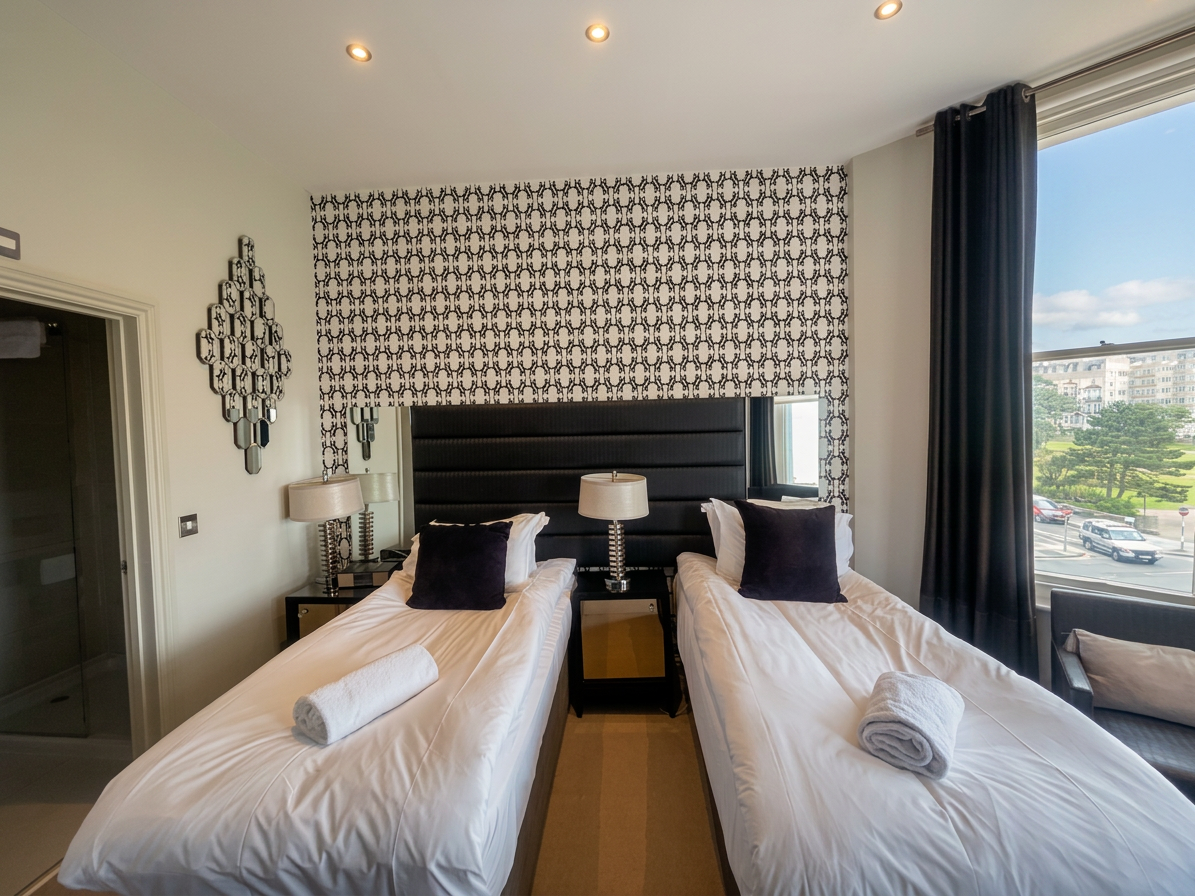 Hastings House Bedroom 5 — twin configuration with sea views through bay window