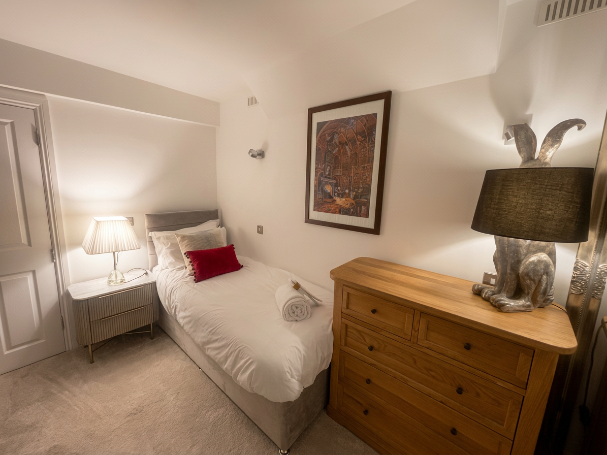 Hastings House Bedroom 9 — cosy single bed with hare lamp and botanical artwork