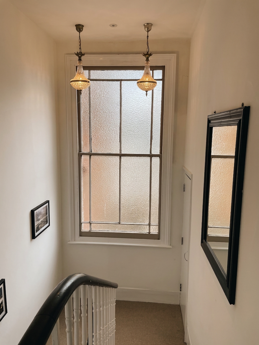 Hastings House landing with two brass pendant lights and large sash window